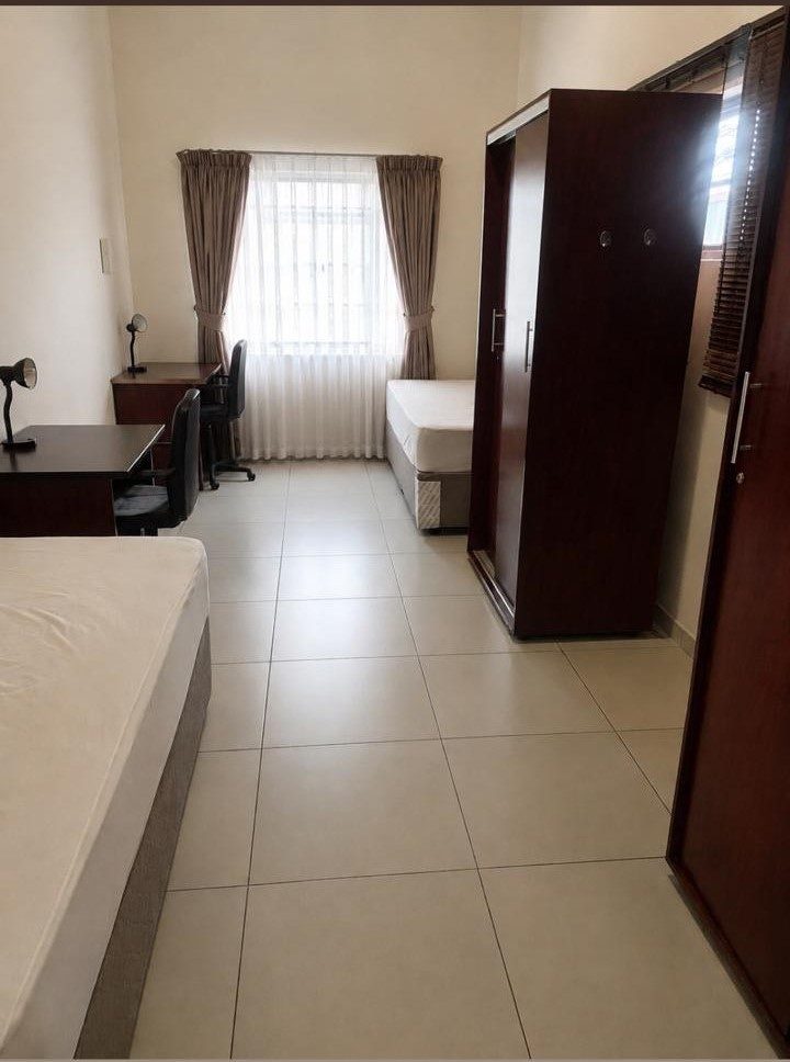 Furnished double room at K1 Rentals — two beds, two study desks and cupboards